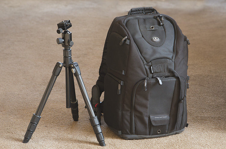 a tripod and camera bag as an example of what to pack for a travel photography vacation