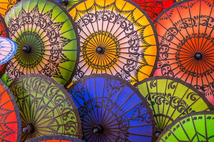 A display of colorful Burmese umbrellas showing blue, green, yellow and orange umbrellas