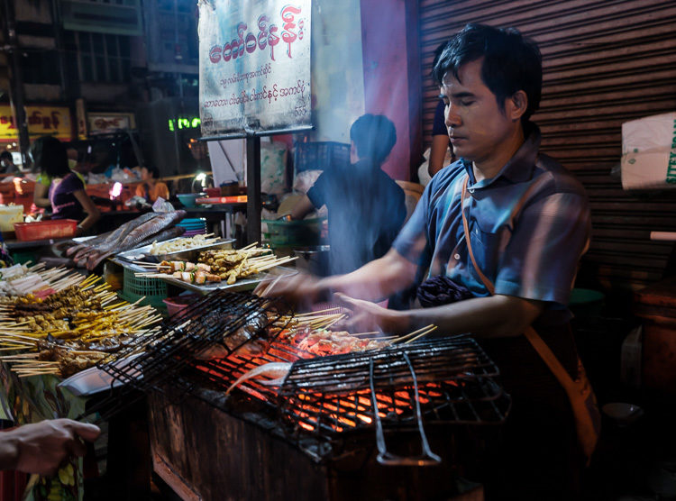 Portrait of Burmese man cooking and selling food in the streets of Yangon at night