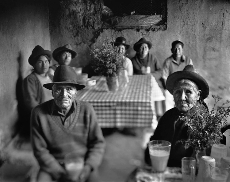classic portrait of a Peruvian family as they sit in their dining room wearing traditional clothes, taken using a large format camera