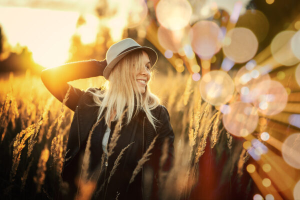 woman in field at sunset with bokeh image background applied