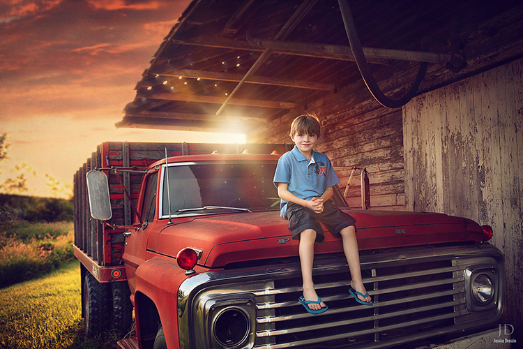 family photograph of my kid on an old truck with the sun setting behind him