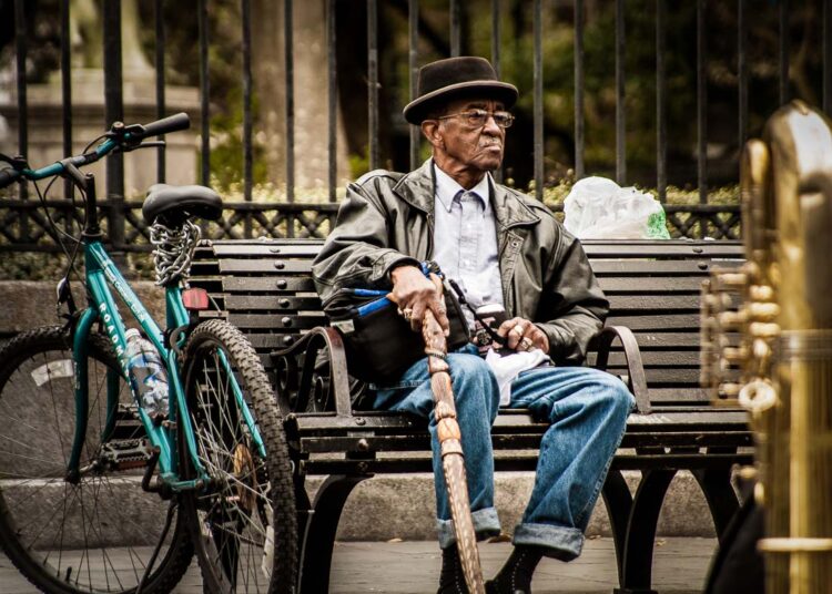with long camera lenses, it's possible to photography people from a distance without them knowing, like this image of a man on a bench in New Orleans