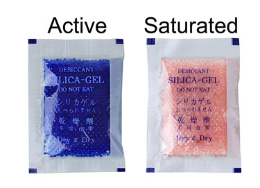 Silica gel packets for your camera bag help keep it dry.  Two packets pictured, showing an active and saturated state