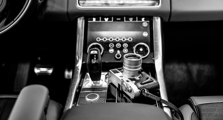 car interior showing stick shift and camera comparing manual transmission of cars with manual mode on a camera - both for more experienced users