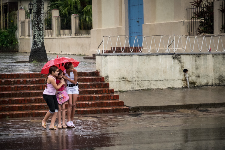 Street photograph of 3 girls in the rain in Vinales Cuba