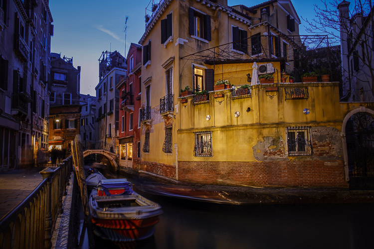 venice at night with a building lit up across the canal