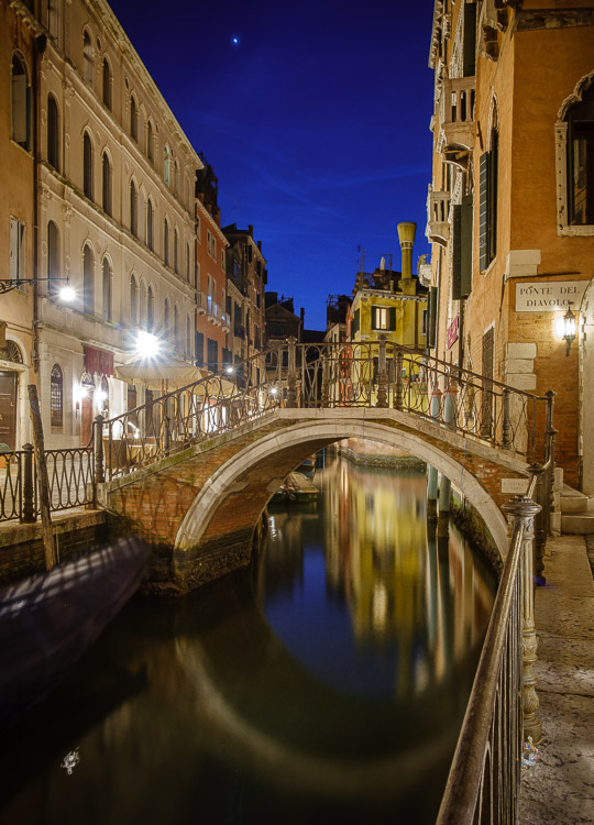 reflection of a building in the water of a venice canal at night