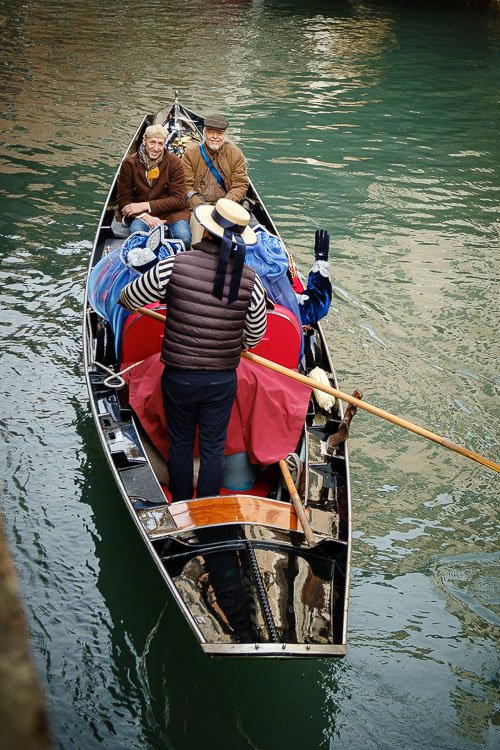 Tour leader and guest in gondola on Venice canal