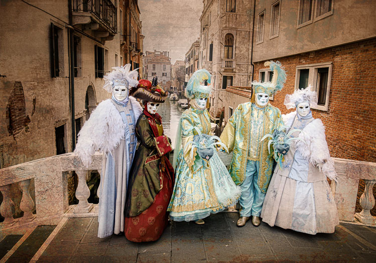 Masked models on a bridge over a canal in Venice.