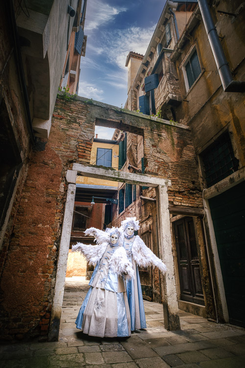 Bird characters posing in the archway of the empty courtyard edited with Luminar 4 sky replacement feature