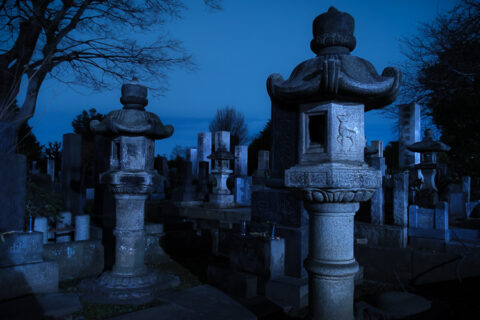 A cemetery photographed at night with the tombs lit in the moonlight