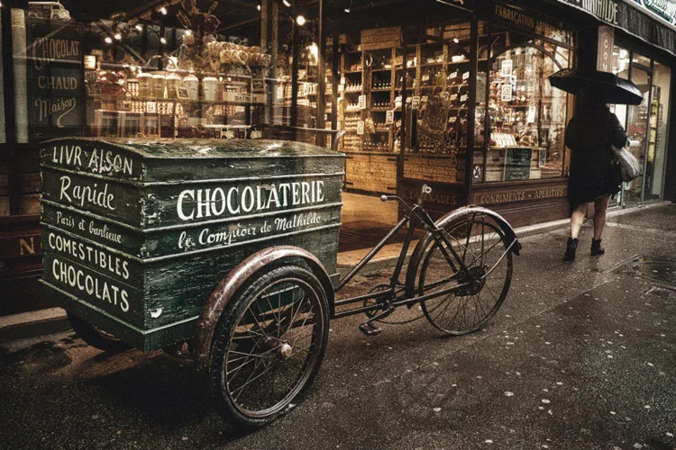 an antique chocolaterie bicycle on the street edited to bring out the contrast, shadows, clean whites and highlights as a style of it's own